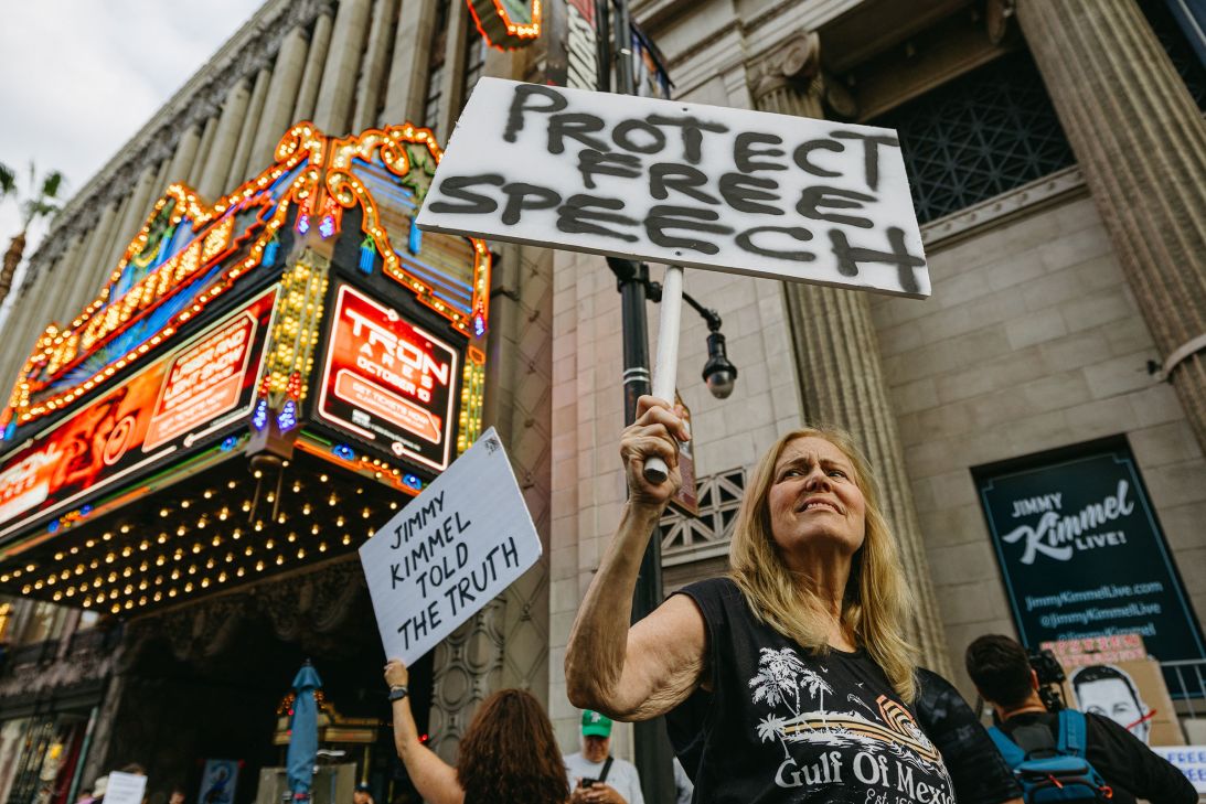 A demonstrator holds a sign reading