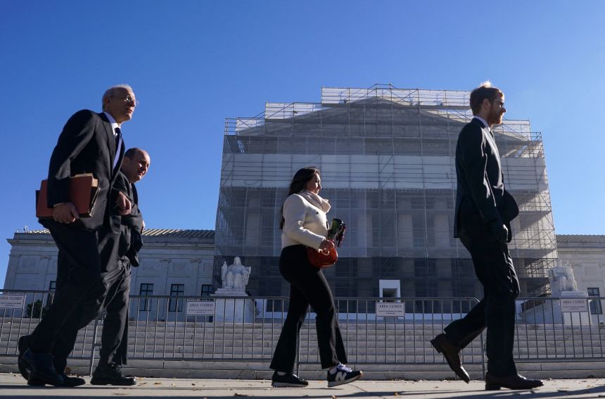 Members of the public walk outside the Supreme Court to attend oral arguments on President Donald Trump's bid to preserve sweeping tariffs.