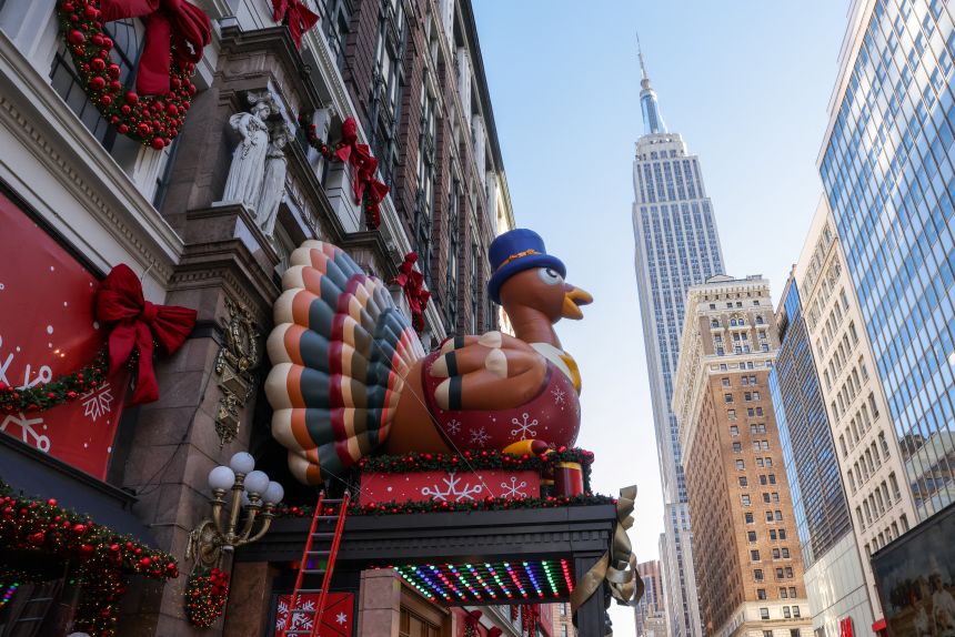 Decorations for Macy's Thanksgiving Day Parade and the holidays are installed outside Macy's Herald Square, as the Empire State Building rises in the background, in New York City on November 24, 2025.