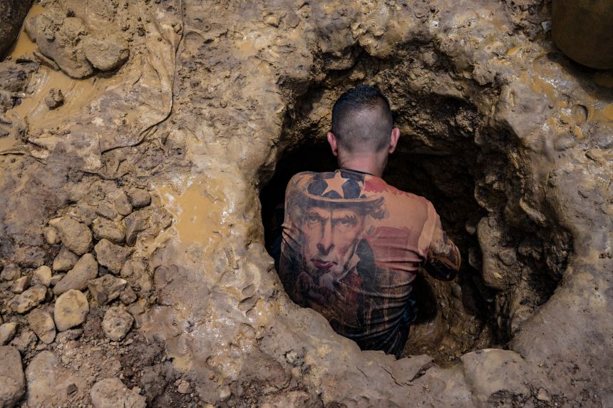 A Venezuelan miner wearing a shirt with the image of Uncle Sam works digging in a mine to extract gold, which will then be sold in El Callao, Bolivar State, Venezuela, on August 29, 2023.