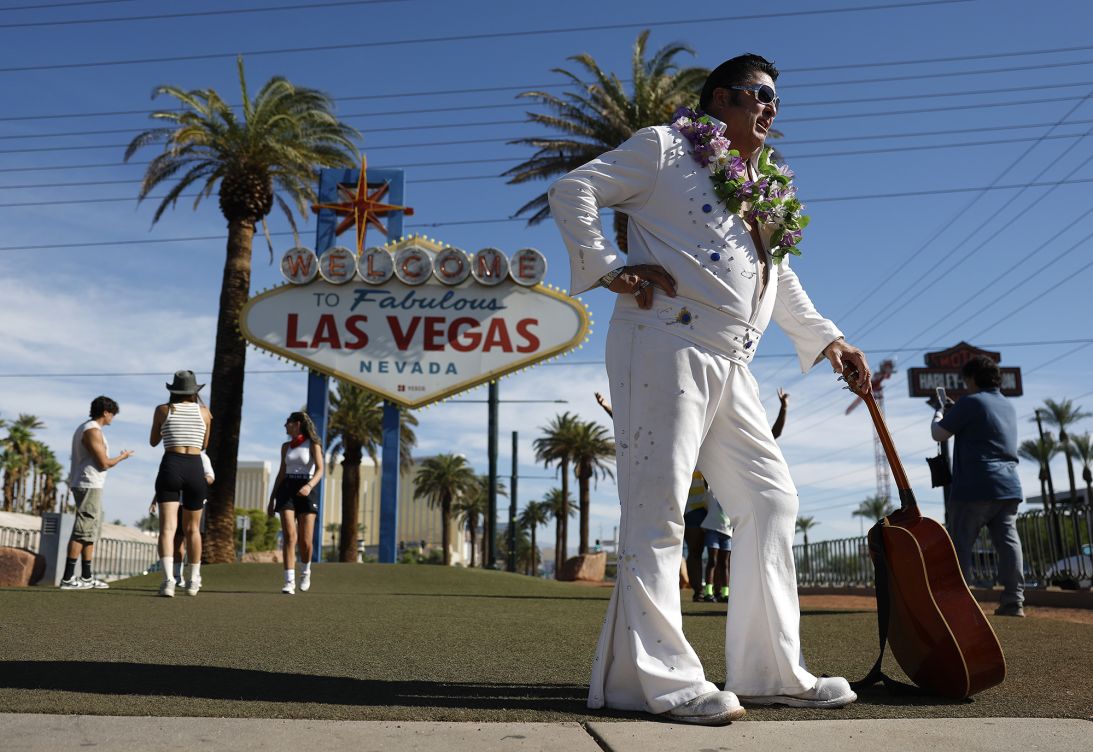 Elvis impersonator Mark Rumpler stands near the Welcome to Fabulous Las Vegas sign last year.