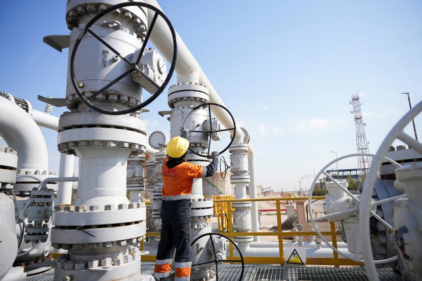 A worker operates valves at the Rumaila oil field, as the country cuts nearly 1.5 million barrels per day of output amid halted exports following the closure of the Strait of Hormuz, in Basra, Iraq, on March 4, 2026.