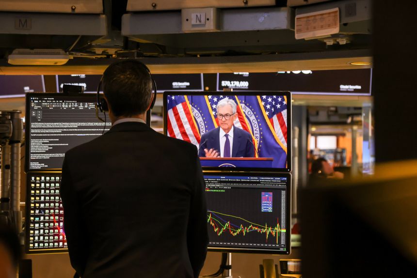 A screen shows Federal Reserve Chair Jerome Powell speaking after a Federal Open Market Committee meeting, on the floor of the New York Stock Exchange on January 28, 2026.