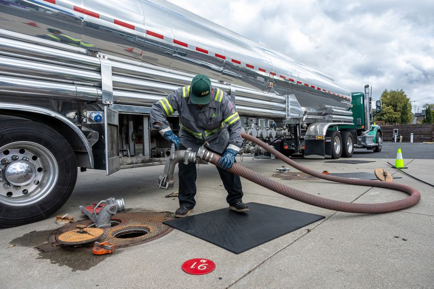 A worker prepares a fuel refill hose at a Chevron gas station in Rodeo, California on Monday. Oil surged as the first impacts of the war in the Middle East began to be felt.