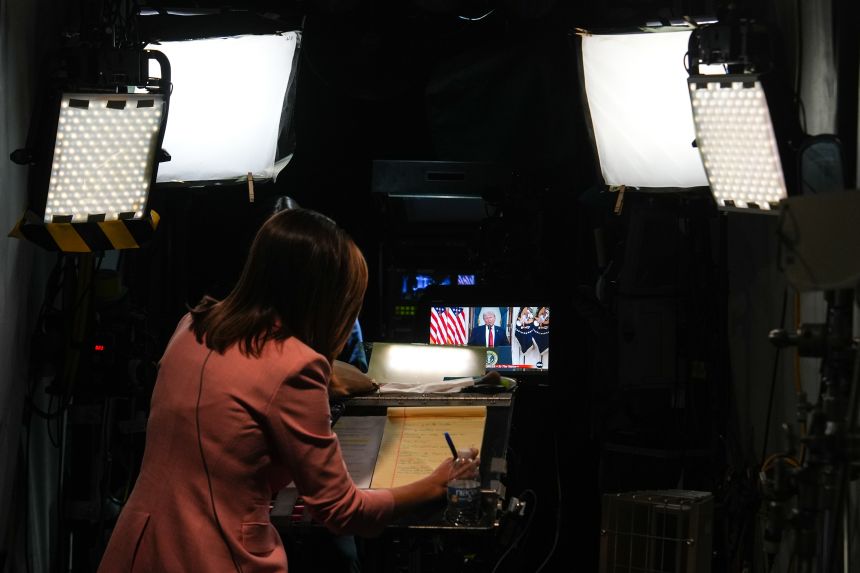 A journalist prepares for a stand-up as President Donald Trump speaks about the Iran war at the White House.