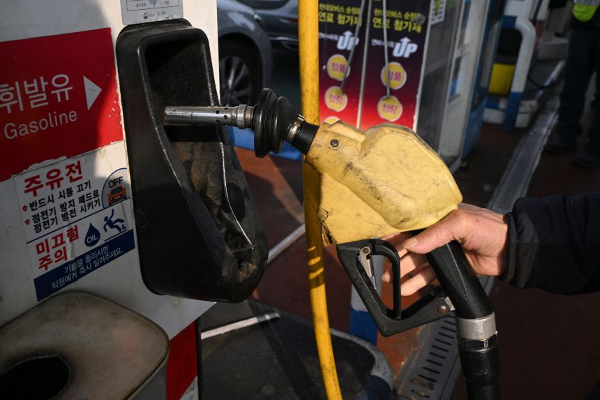 A man prepares to fill up his car at a petrol station in Seoul.