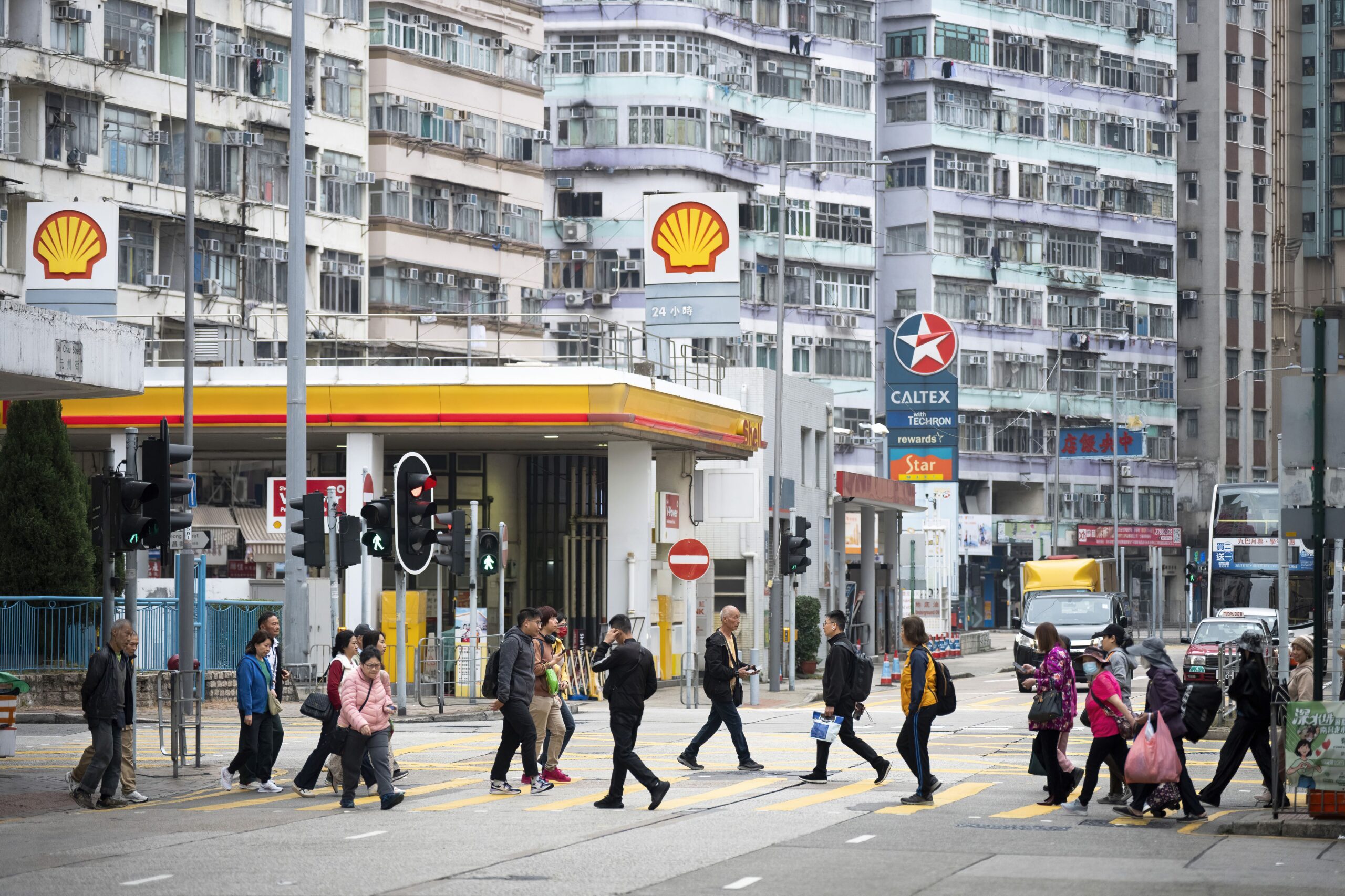 Sebastian Ng/SOPA Images/LightRocket/Getty Images via CNN NewsourcePedestrians walk through a zebra crossing in front of the gas stations logos from the energy and petrochemical company