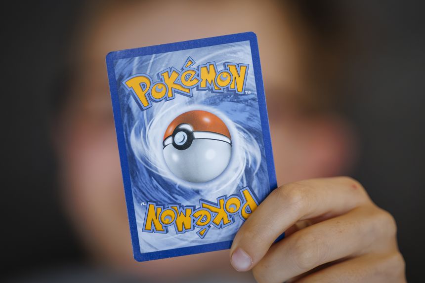 A boy looks at Pokemon cards in a scrapbook on August 18, 2025 in Berlin, Germany.