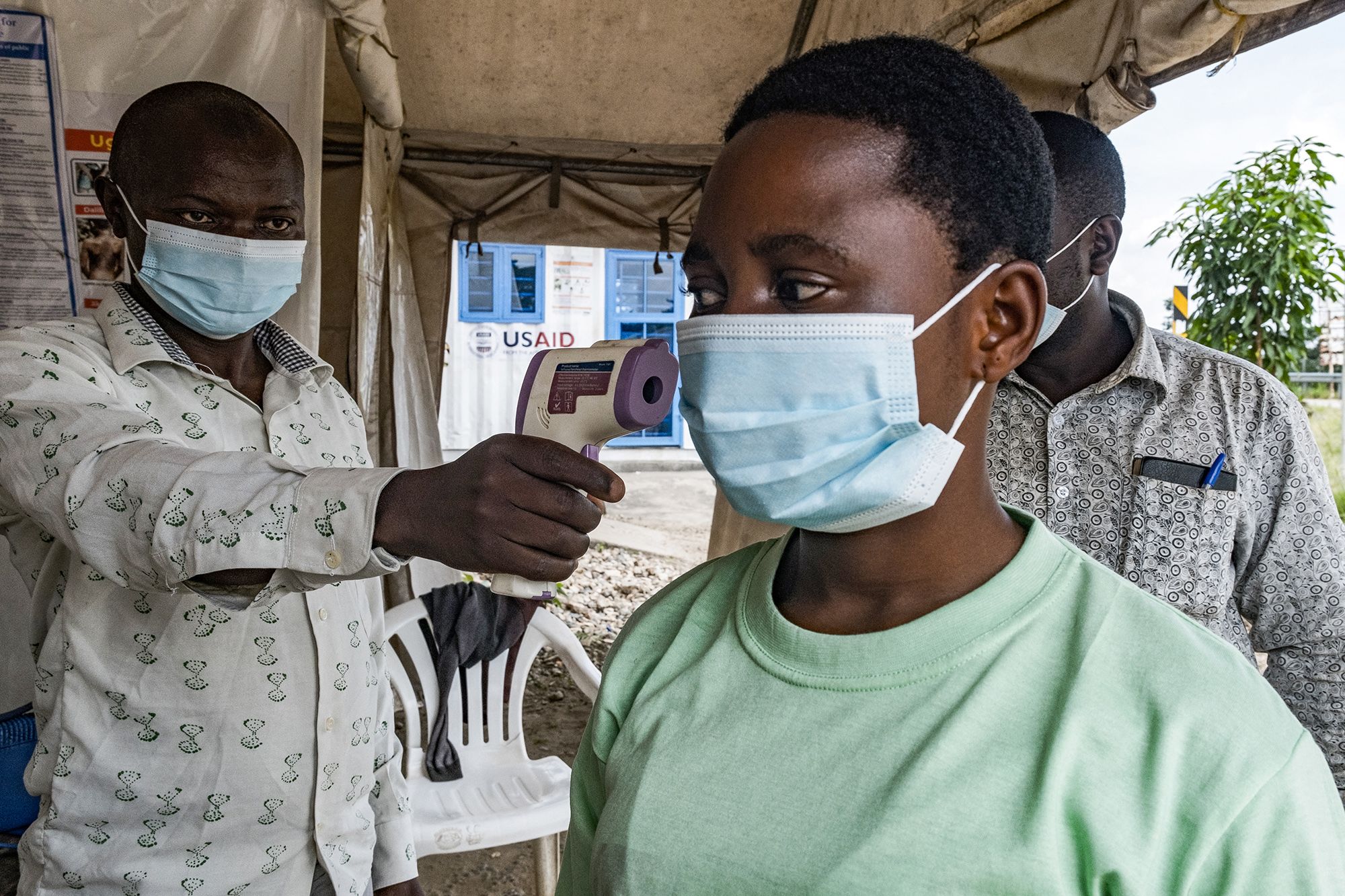 <i>Badru Katumba/AFP/Getty Images via CNN Newsource</i><br/>A border health officer at the Busunga crossing between Uganda and the Democratic Republic of Congo checks a traveler's temperature in Bundibugyo