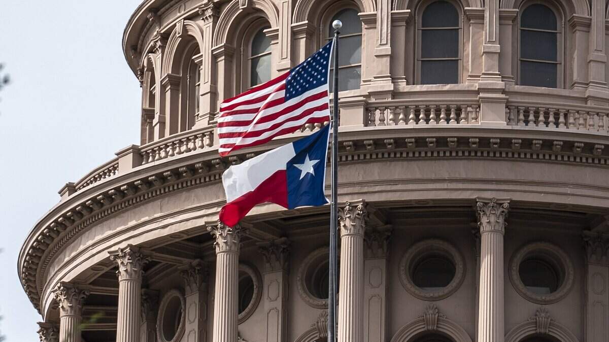 The U.S. and Texas state flags fly outside the state Capitol building on July 12, 2021, in Austin, Texas. (Sergio Flores/Getty Images/TNS)